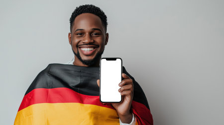 A mockup of the phone in the hand of a happy black guy. A young African student advertises his educational institution in Germany. Education and tourism. Immigration and citizenship. The German flag. Applying for a visa to Germany.の素材