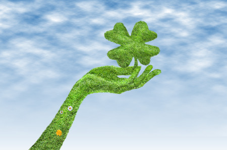 Hand with a four-leaf clover isolated, Hand covered with grass, a clover in his hand, a clover and a hand covered with green grassの写真素材