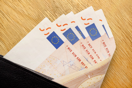 leather black leather wallet with money, some banknotes in black purse, open purse with paper money with moneyの写真素材