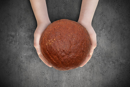 Women holds a bread in his hands as a welcome. Loaf of bread in his hands.holds a bread in his hands