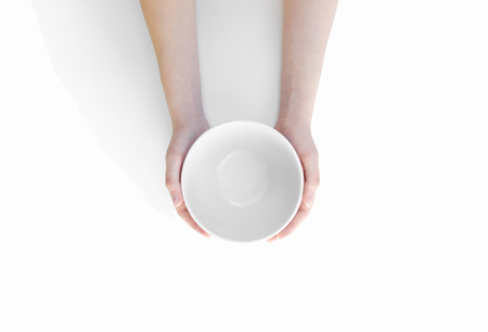 Hunger concept. Female holding empty plate waiting for food isolated. Empty plate in handの写真素材