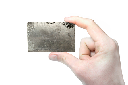 Hand with blank business card. Blank paper card in hand, isolated on white background. Paper business card with a picture texture of old metal.の写真素材
