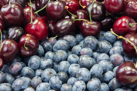 Fresh blueberries and cherries backgroundの写真素材