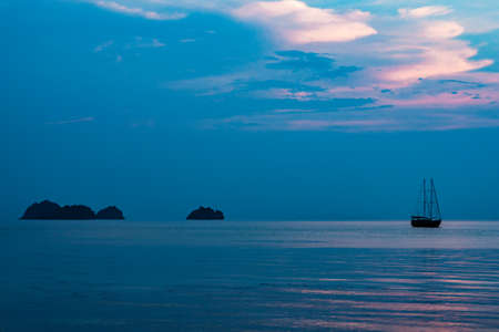 Ship in the ocean dark sunset skyの写真素材