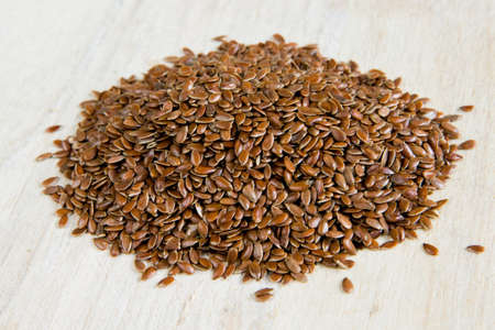 A handful of flax seeds on a rustic surfaceの写真素材