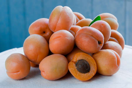 Ripe apricots with green leaves in a cutの写真素材