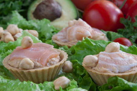 Canapes with hummus and salmon on a vegetable backgroundの写真素材