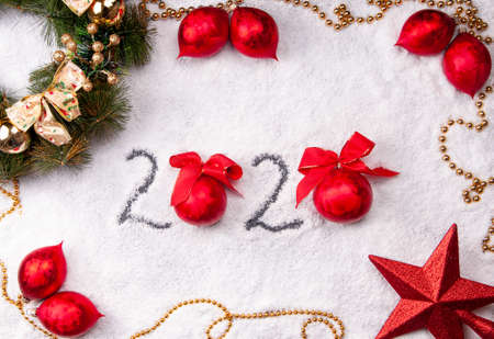 2020 on Christmas snowy background with red decorationsの写真素材