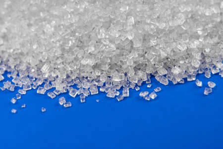 White sugar crystals close-up on a blue backgroundの写真素材