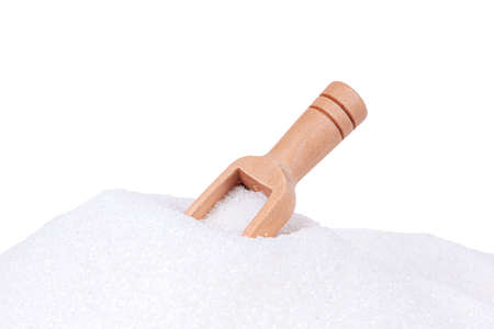 Heap of white sugar with a wooden spoon on a isolated backgroundの写真素材