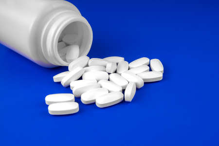 Pack of scattered tablets on a blue backgroundの写真素材