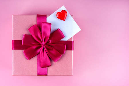 Present with Love note with red heart on pink background mock up, copyspaceの写真素材