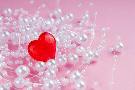 Valentine's day romantic card red heart with white beads on a pink backgroundの写真素材
