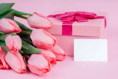 Gift with flowers tulips on a pink background for Valentine's Day, for Mother's Day, mock upの写真素材