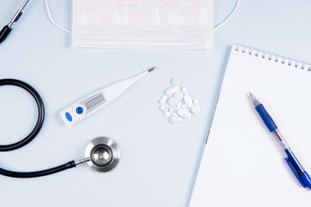 Flatlay doctor workplace with stethoscope and with mask and with notepad mock up.の写真素材