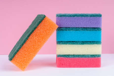 Multicolored sponges for washing dishes on top of each other on  pinkの写真素材