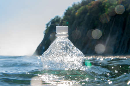A plastic bottle floats on the water surface by the ocean.の写真素材