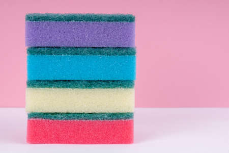 Multicolored sponges for washing dishes on top of each other on  pinkの写真素材