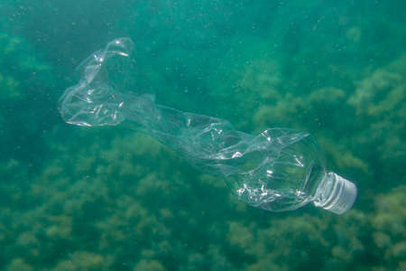 Plastic bottle underwater at the bottom of the ocean. Planet pollution concept.の写真素材