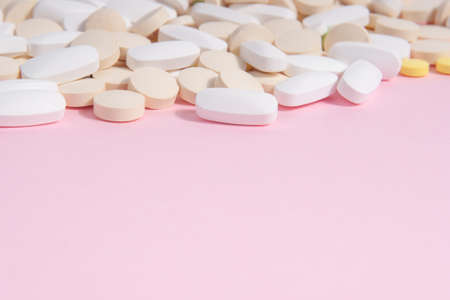 Many different pills on a pink background. Female health conceptの写真素材