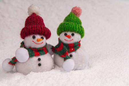 Two cute snowmen stand in the snow and smile during snowfall with copy space. Concept christmas.の写真素材