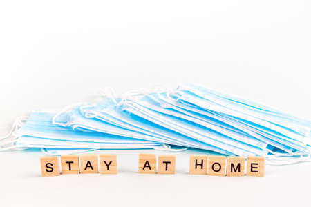Text "stay at home" with copy space on the background of protective face masks. Virus and epidemic concept.の写真素材