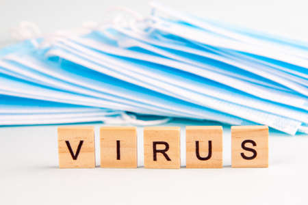 Text "virus" with copy space on the background of protective face masks. Virus and epidemic concept.の写真素材