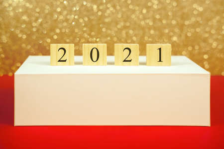 Numbers 2021 on a pedestal on a gold background bokeh with mock-up. New year and christmas concept.の写真素材