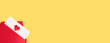 Banner red open envelope with a sheet of paper with a heart on a yellow background with copyspace. Valentine's day holidays concept and love notes, christmas and new year letters for Santa Clausの写真素材