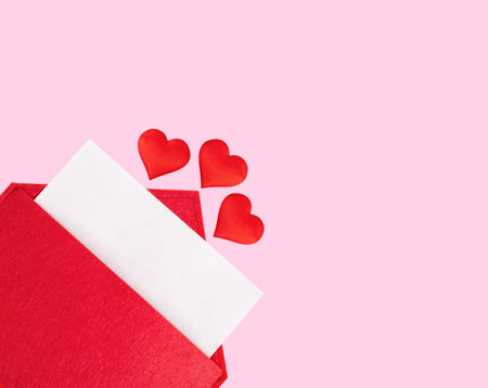 Red open envelope with a sheet of paper with a hearts on a pink background with mock-up. Valentines day holidays concept and love notes, christmas and new year letters for Santa Claus.の写真素材