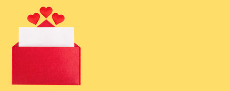 Banner red open envelope with a sheet of paper with a hearts on a yellow background with mock-up. Valentines day holidays concept and love notes, christmas and new year letters for Santa Claus.の写真素材
