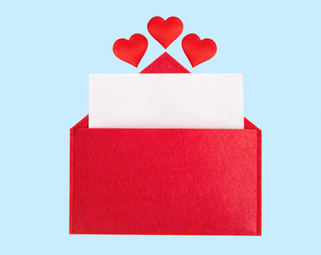 Red open envelope with a sheet of paper with a hearts on a blue background with mock-up. Valentines day holidays concept and love notes, christmas and new year letters for Santa Claus.の写真素材