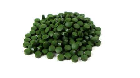Spirulina algae tablets isolated on white background spinning to the left. Nutritional supplements, vitamins and health conceptの写真素材