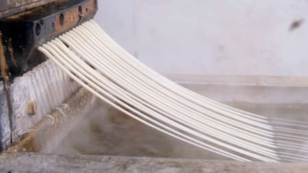 Recycled plastic comes out of the extruder machine Concept of recycling, plastic, industry, factories. Continuous extrusion with cooling in water to be processed into a pellet.の写真素材