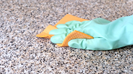 Hand Cleaning Kitchen Work Surface with Rubber Gloves and Disinfectant Spray. The concept of cleaning, help around the houseの写真素材
