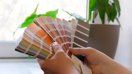 The designer holds fan of color guide in hand. Selection of colors for the color of the walls apartment distribution during promotion concept.の写真素材