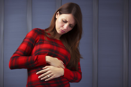 Unhappy woman holding her stomach in pain with empty space for text or designの素材