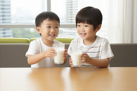 Happy asian children drinking fresh milk happily - copy space available for text and advertisingの素材