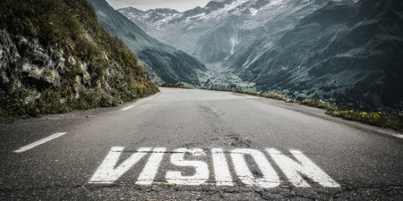 Word vision painted on an empty winding mountain road, representing the path forward, future plans, goals, and opportunities in a challenging but promising landscapeの素材