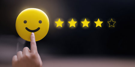 Hand selecting a happy smiling emoticon face, choosing a five-star rating indicating excellent service and positive customer satisfaction feedback on a dark backgroundの素材