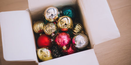 Colorful vintage christmas baubles filling a cardboard box, symbolizing holiday preparation, festive decoration, and the joy of creating a celebratory atmosphere for the winter seasonの素材