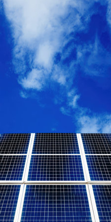 Solar panels are utilizing sunlight to generate sustainable electricity, contributing to renewable energy solutions while positioned against a clear blue sky with white cloudsの素材