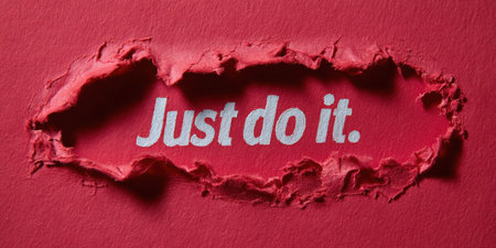 Just do it slogan emerges in white text through a ragged hole in a textured red paper background, symbolizing motivation, breakthrough, and determinationの素材