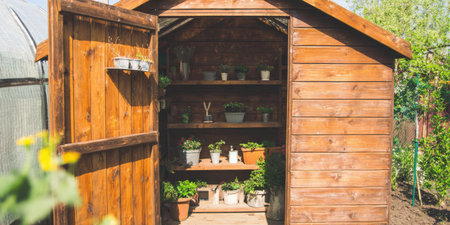 Wooden shed, designed for gardening activities, standing open with multiple shelves filled with various potted plants and seedlings inside, illustrating a hobby for cultivating natureの素材