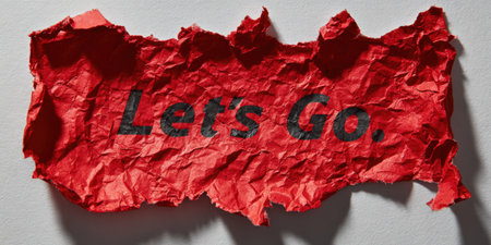 Red crumpled paper with bold let's go text, textured grunge surface and shadow on white background conveying urgency, motivation, new beginnings and a call to actionの素材