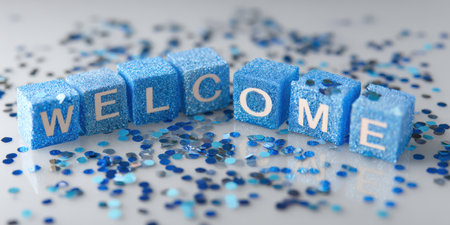 Welcome word spelled out with blue glitter letter cubes scattered with matching blue metallic confetti on a reflective white surface, creating a festive greeting atmosphereの素材