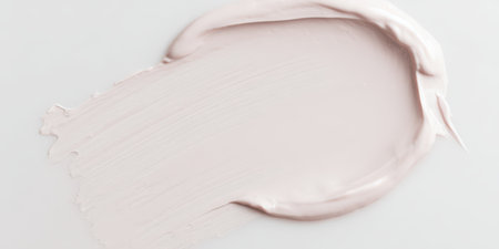 Light pink cosmetic cream creating a thick, smooth texture swatch on a clean white background, showcasing beauty product consistency for skincare and makeup applicationsの素材