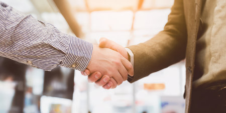 Two business colleagues establishing a professional connection and sealing a new project agreement with a firm handshake, symbolizing partnership, trust, and successful cooperationの素材