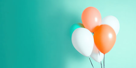 Balloons in various shades of white, orange, and teal are floating together, creating a vibrant and festive display against a complementary background, symbolizing celebration, fun, and joyの素材