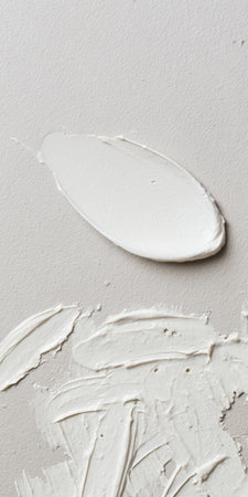 White palette-knife paint layered into thick vertical strokes on a light gray surface, creating subtle abstract texture and a neutral contemporary background with copy spaceの素材